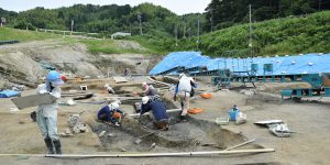 周りを丘陵に囲まれた谷間の河跡を掘っているところ。