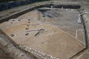 古代の川跡とその隣にたつ建物の写真です。