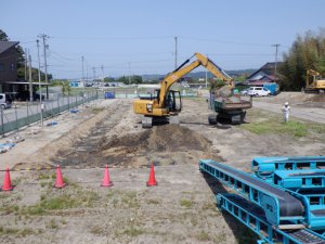 調査箇所の表土を重機で取り除く作業の様子