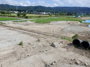 ふるこ・こくぶ遺跡の調査前の様子です。道路の向こうに能登国分寺跡が見えます。